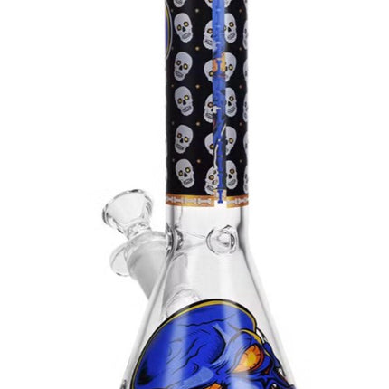 Glass water beaker with blue monster skull graphic and gold rim, clear base.