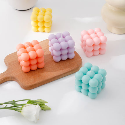 Cube candle with bubble-sphere wax clusters, pink, purple, yellow, and teal