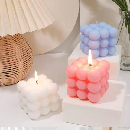 Pastel bubble cube scented candles: white, pink, and blue, each with a visible wick