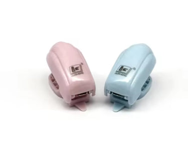 Two mini staplers in pink and light blue, top views with staple opening