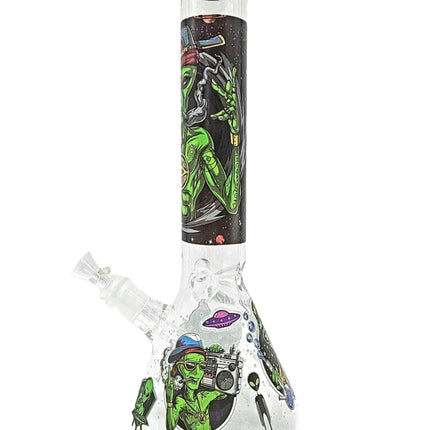 Clear glass water beaker with green alien artwork and slanted angled body.