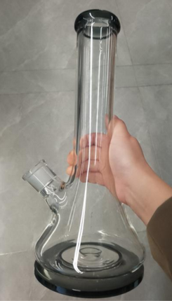 Tall clear glass water pipe bong with dark base ring, held by hand