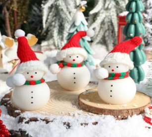 Set of three snowman-shaped Christmas candles with red hats and green scarves