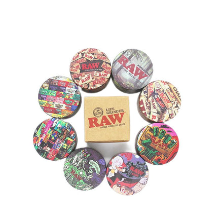 Metal herb grinder set with colorful printed lids surrounding RAW-branded box