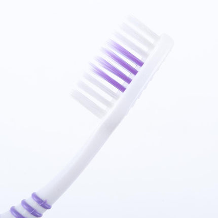 Curved soft-bristle toothbrush with purple bristles and white handle