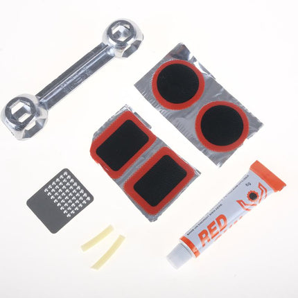 Bicycle tire puncture repair kit parts: wrench, round patches, glue tube, and yellow strips
