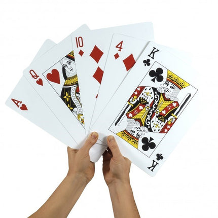 Jumbo playing cards held in hands, fanned with aces, tens, king, and club/heart suits