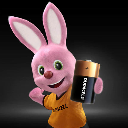 Duracell D alkaline battery held by a Duracell-branded rabbit plush character