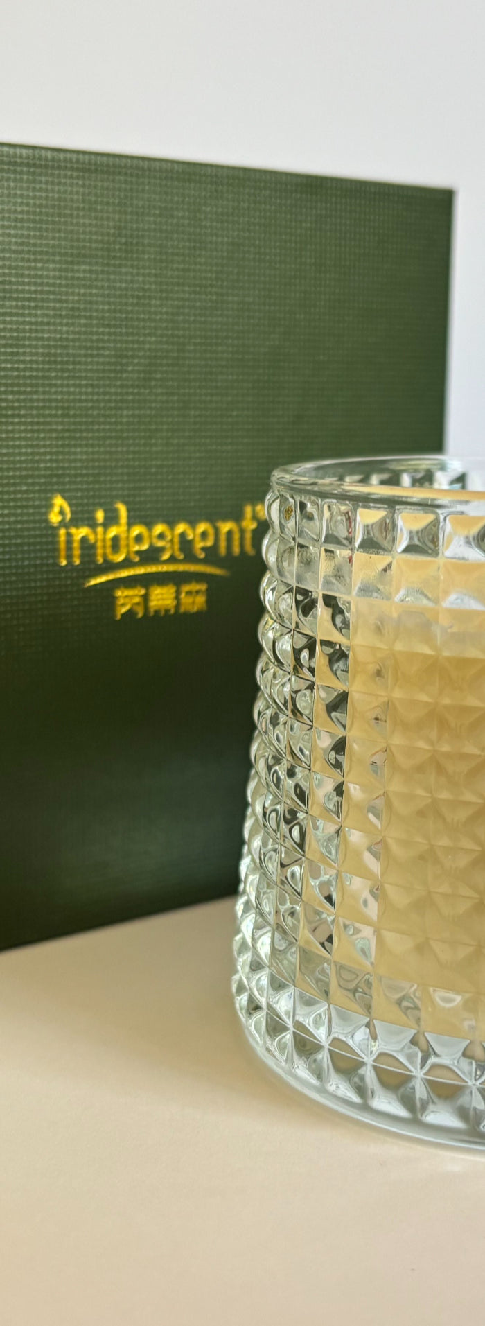 Soy candle in faceted glass jar with green gift box behind
