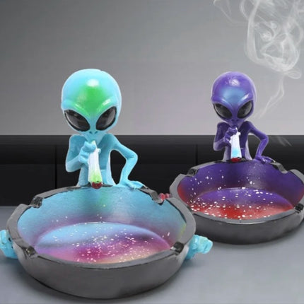 Two alien ashtrays: light blue and purple figurines with galaxy bowls