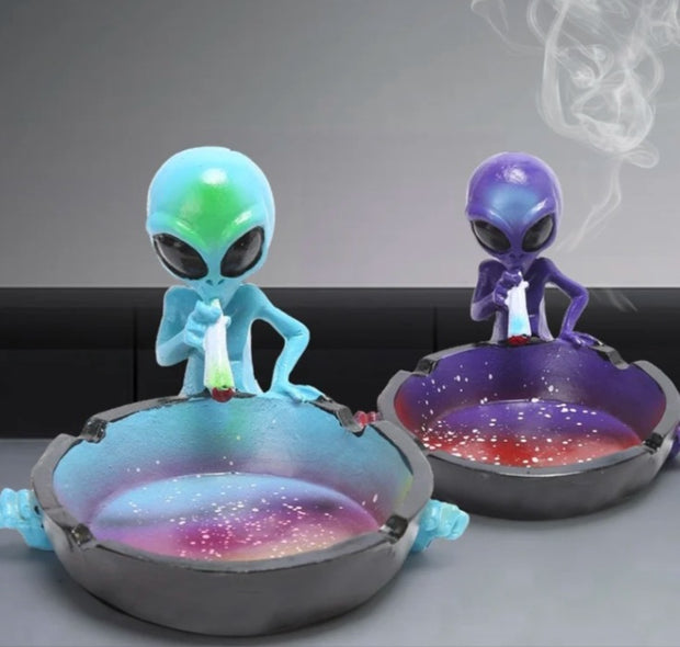 Two alien ashtrays: light blue and purple figurines with galaxy bowls
