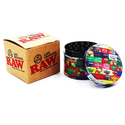 4-piece metal herb grinder with printed lids, open black base, and RAW box