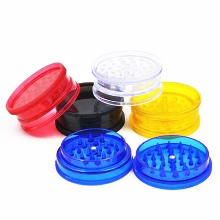 Assorted plastic herb grinder lids in red, black, yellow, and blue with clear top panels