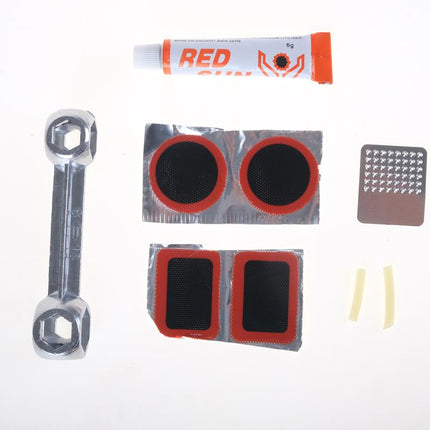 Tire puncture repair kit pieces: wrench, red-and-black patches, glue tube, and spare inserts