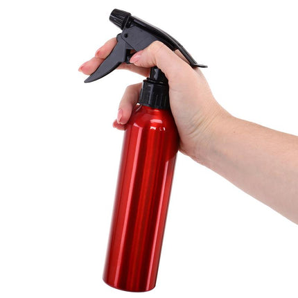 Red aluminium spray water bottle with trigger sprayer, held in hand, 280 ml