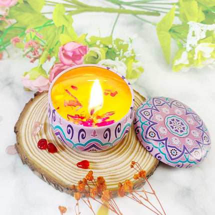 Lit votive soy candle in patterned purple-blue tin, round flame visible
