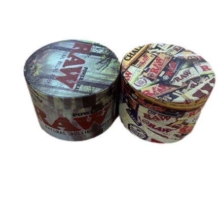 Metal herb grinder with two stacked RAW-themed lids and textured multicolor finish