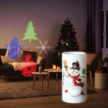 Rotating projector candle casting warm light with snowman artwork on a cylinder