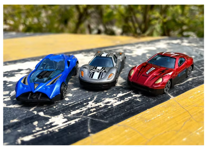 Three 1:64 die-cast racing cars: blue, gray, and red on a track surface
