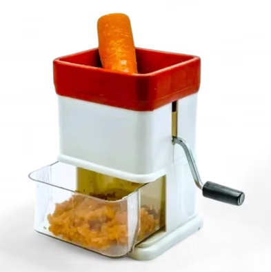 Vegetable grater with red hopper, white body, clear collection box, orange carrot pieces