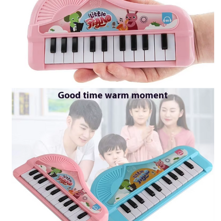 Pink toy electronic keyboard with animal scene, held in a hand