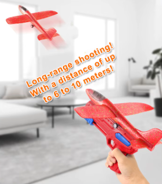 Red toy glider launcher in hand with speckled glider plane for launch