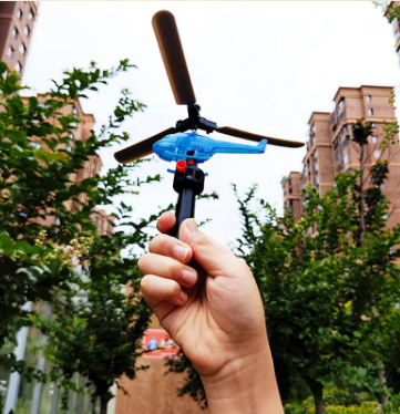 Blue pull-powered outdoor helicopter with three blades, held in a hand