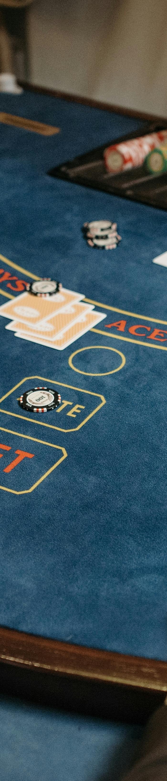 Players enjoying poker at a blue casino table with chips and cards, dealer managing game